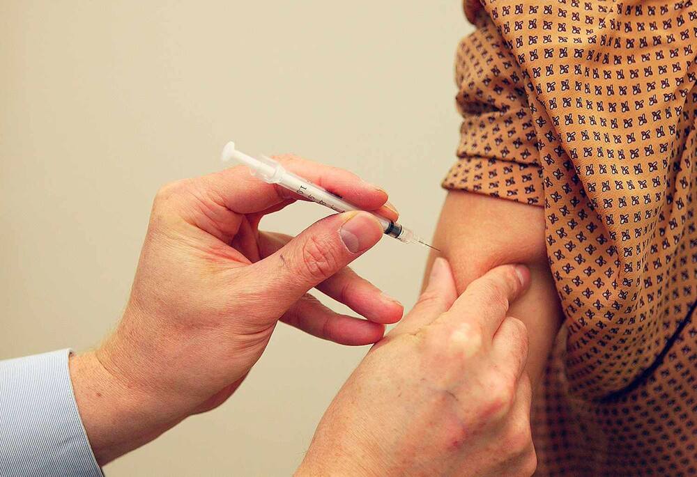 Close-up of a syringe with an allergy vaccine being injected into a patient's arm