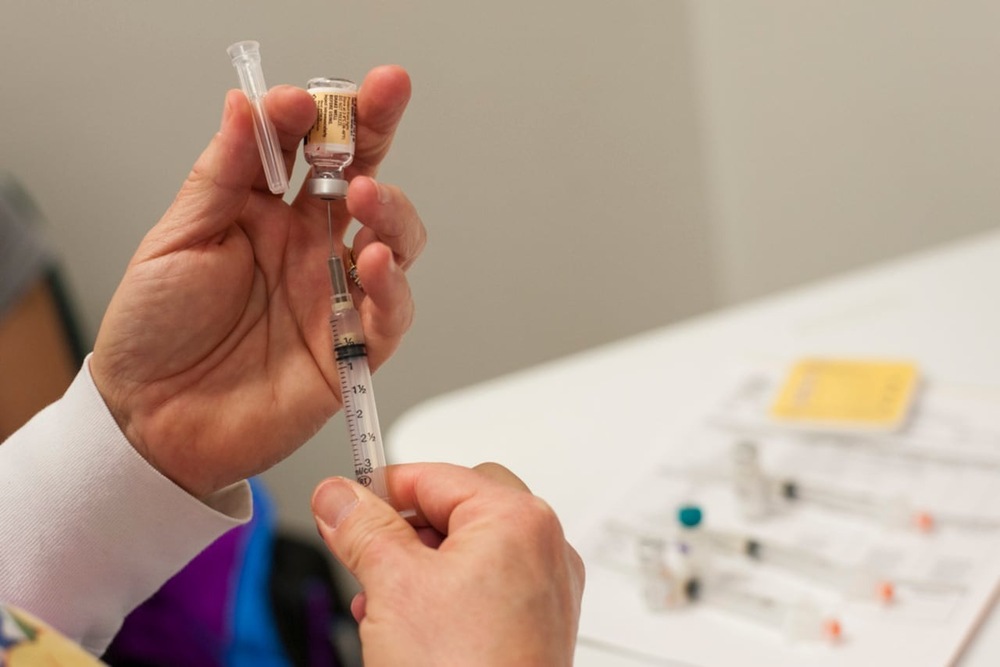 A healthcare professional administers an HPV vaccine to a school-age girl in Pakistan as part of a cervical cancer prevention campaign.