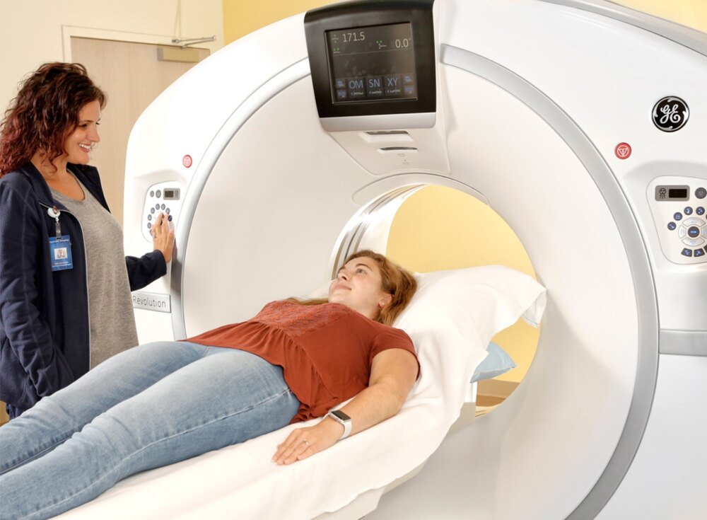 A woman undergoing a CT scan for diagnostic imaging, health monitoring, and medical checkup at a hospital.