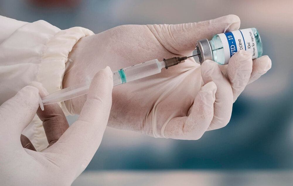 A healthcare worker administering the updated COVID-19 vaccine