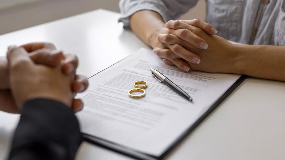 A couple placing their wedding rings on the table, symbolizing divorce or separation