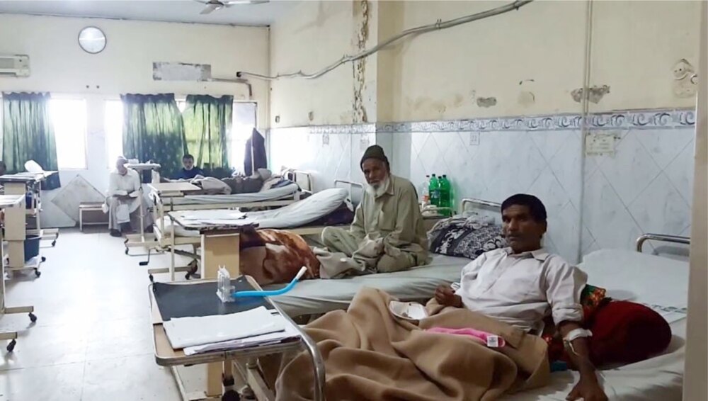 Hospital IPD ward with patients receiving care, some on the beds
