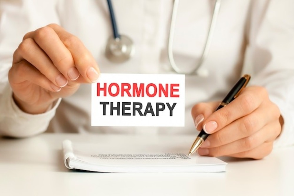 A doctor holding a card that reads 'Hormone Therapy' for menopause treatment and women's health awareness