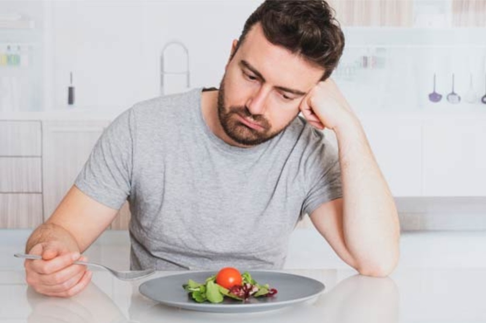 Person eating alone in a depressive mood, showing emotional eating and stress-related food craving