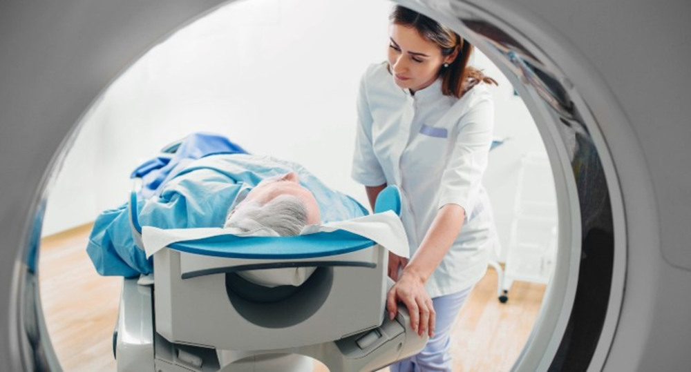 A healthcare professional explains the discogram procedure to a patient before the spinal disk injection test.