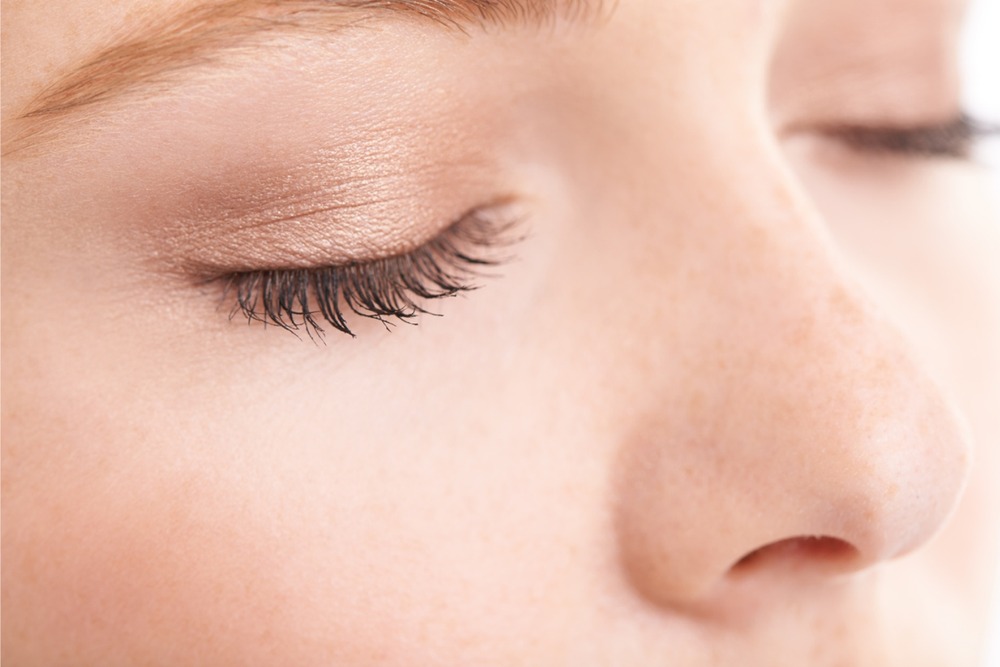 Closed human eye captured mid-blink, symbolizing focused attention and increased brain activity during cognitive effort