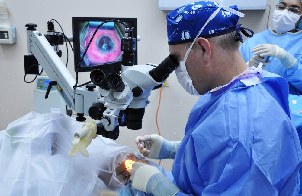 Ophthalmologist performing cornea transplant surgery on a patient in a modern operating room