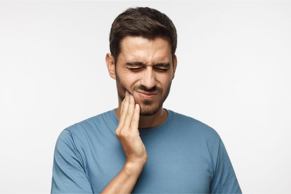 A person showing toothache symptoms due to cavities caused by high blood sugar in diabetes.