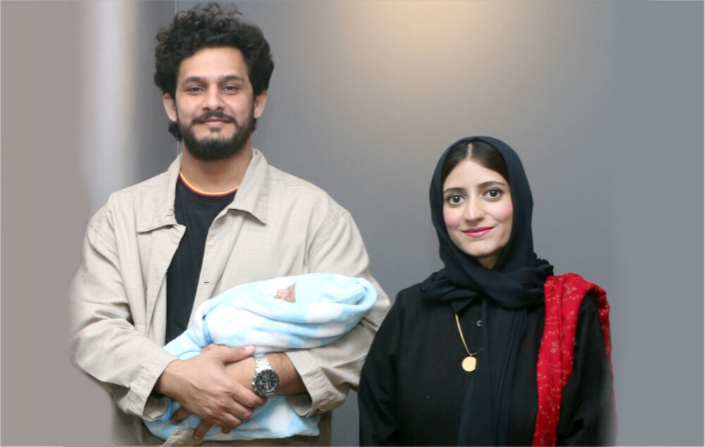 The happy couple holding their healthy newborn baby after successful bile duct cancer surgery during pregnancy at Shifa International Hospital