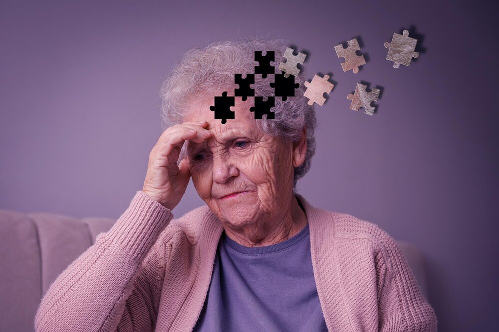 Elderly woman with dementia sitting thoughtfully at home, illustrating memory loss, cognitive decline, and the challenges of dementia in older adults.