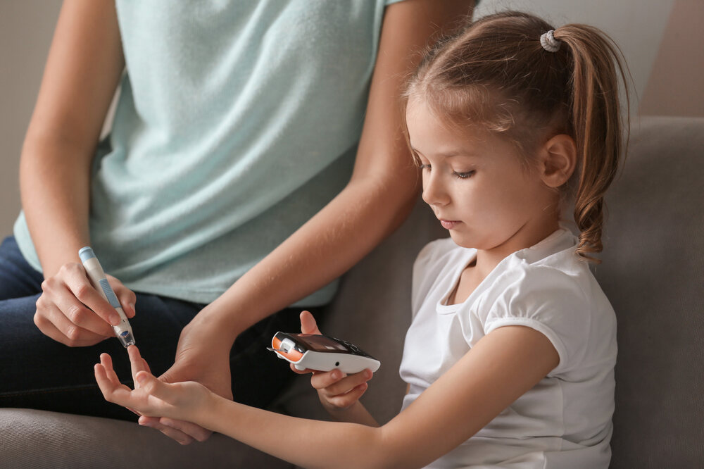 Young girl undergoing a finger-prick blood sugar test for Type 1 diabetes screening