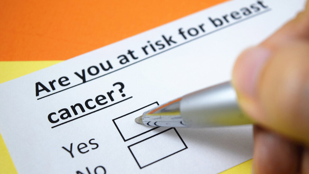 Healthcare professional completing a breast cancer risk assessment form during a patient evaluation