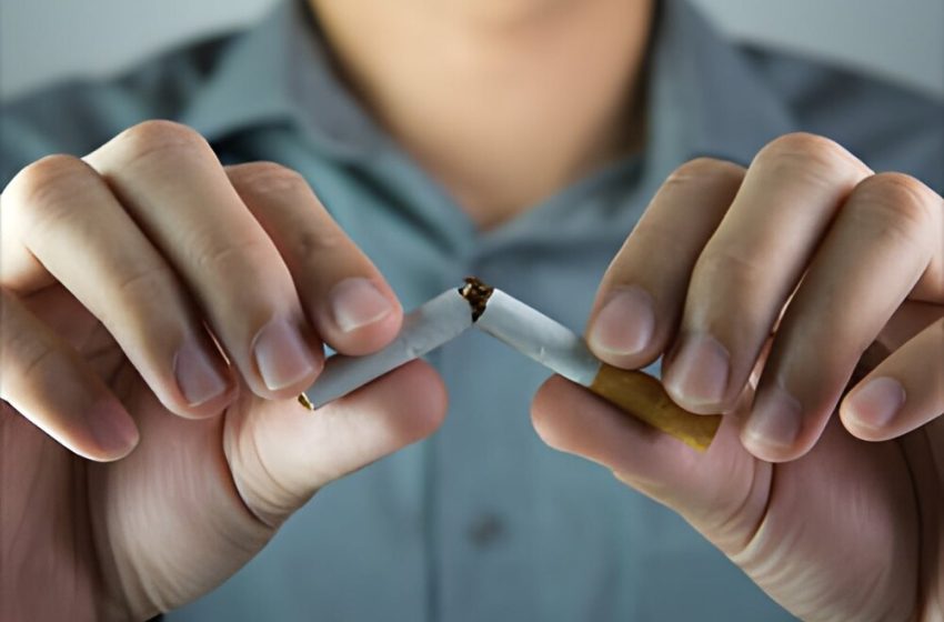 A man breaking a cigarette in half, symbolizing freedom from nicotine dependence