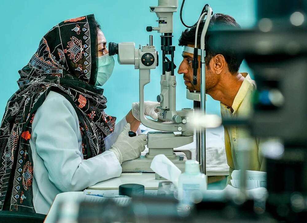 Eye specialist examining a patient's vision at a clinic, highlighting calls for increased investment in eye care on World Sight Day in Pakistan.
