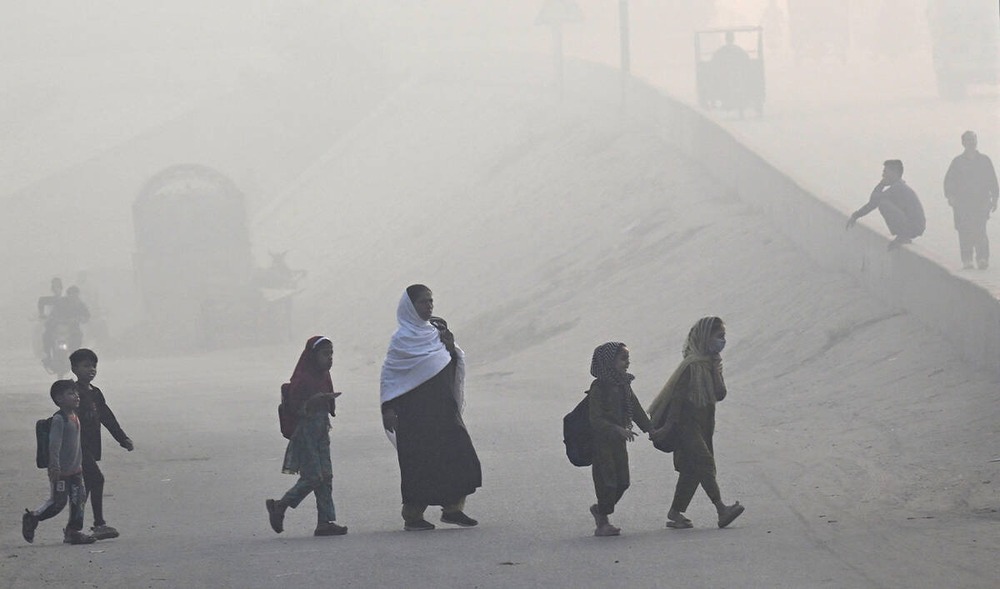 Schoolchildren and a woman walking through thick smog in Lahore as dangerous air pollution raises health concerns across Punjab.