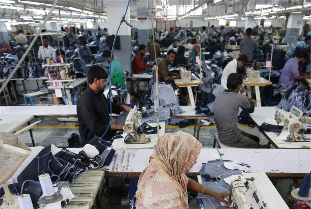 Industrial workers operating sewing machines in a garment factory, highlighting Punjab's new mobile healthcare programme for industrial workers and their families.